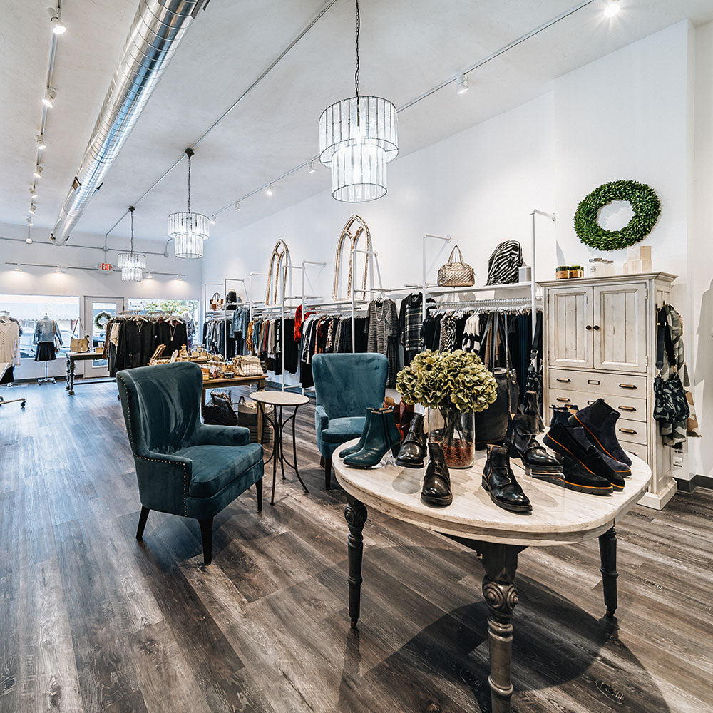 Modern women's clothing boutique with leather shoes, fall clothing, and wingback chairs