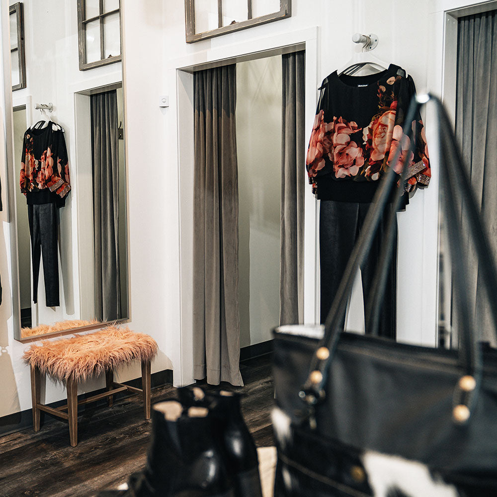 Fitting rooms in women's clothing boutique with ample, comfortable space for changing